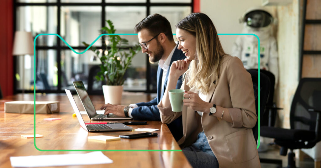 man and woman sitting at laptops