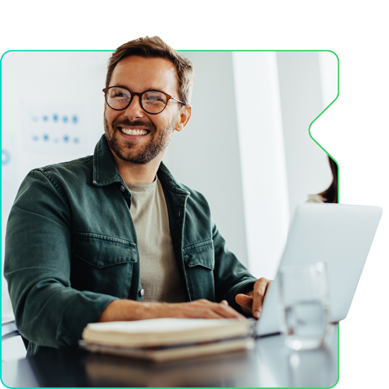 Man smiling while working on a computer