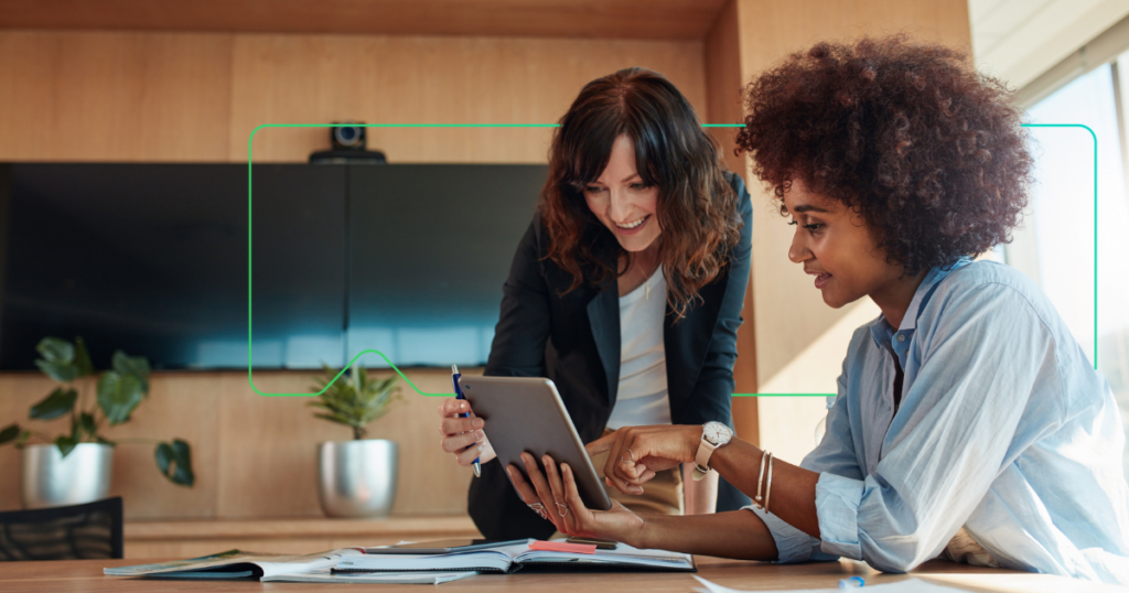 two woman working with a tablet with a synergy learning brand device behind them